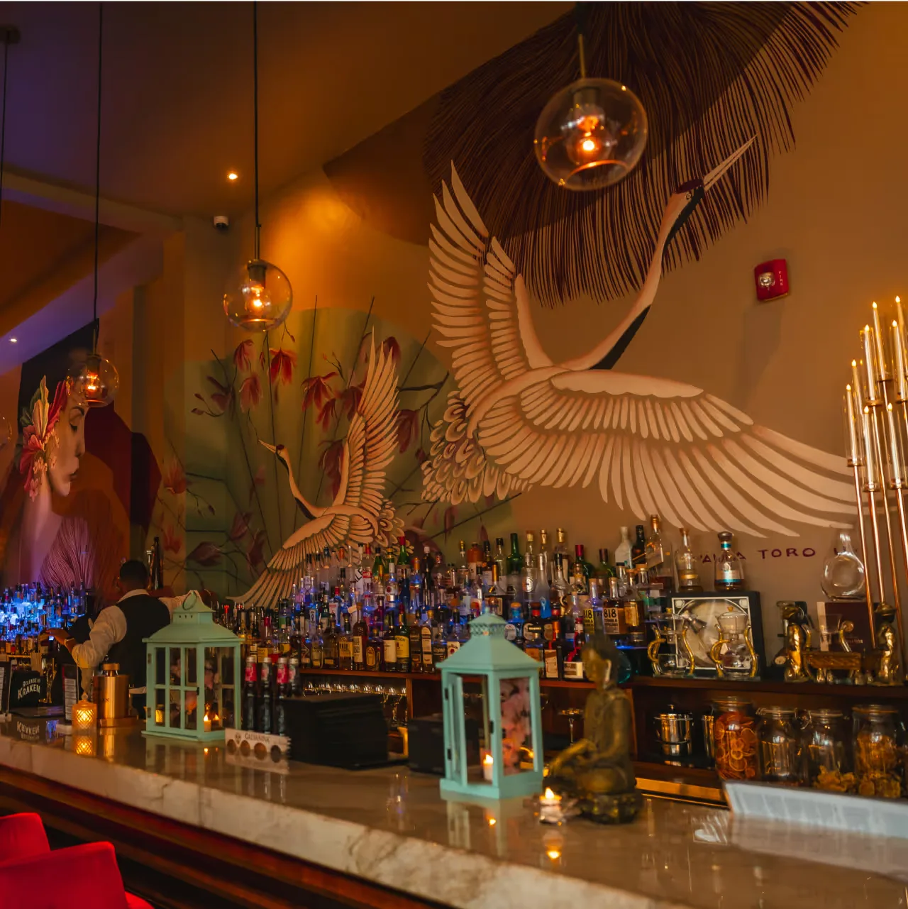 AZIA's bar, with backlit shelves of bottles under a large white crane mural