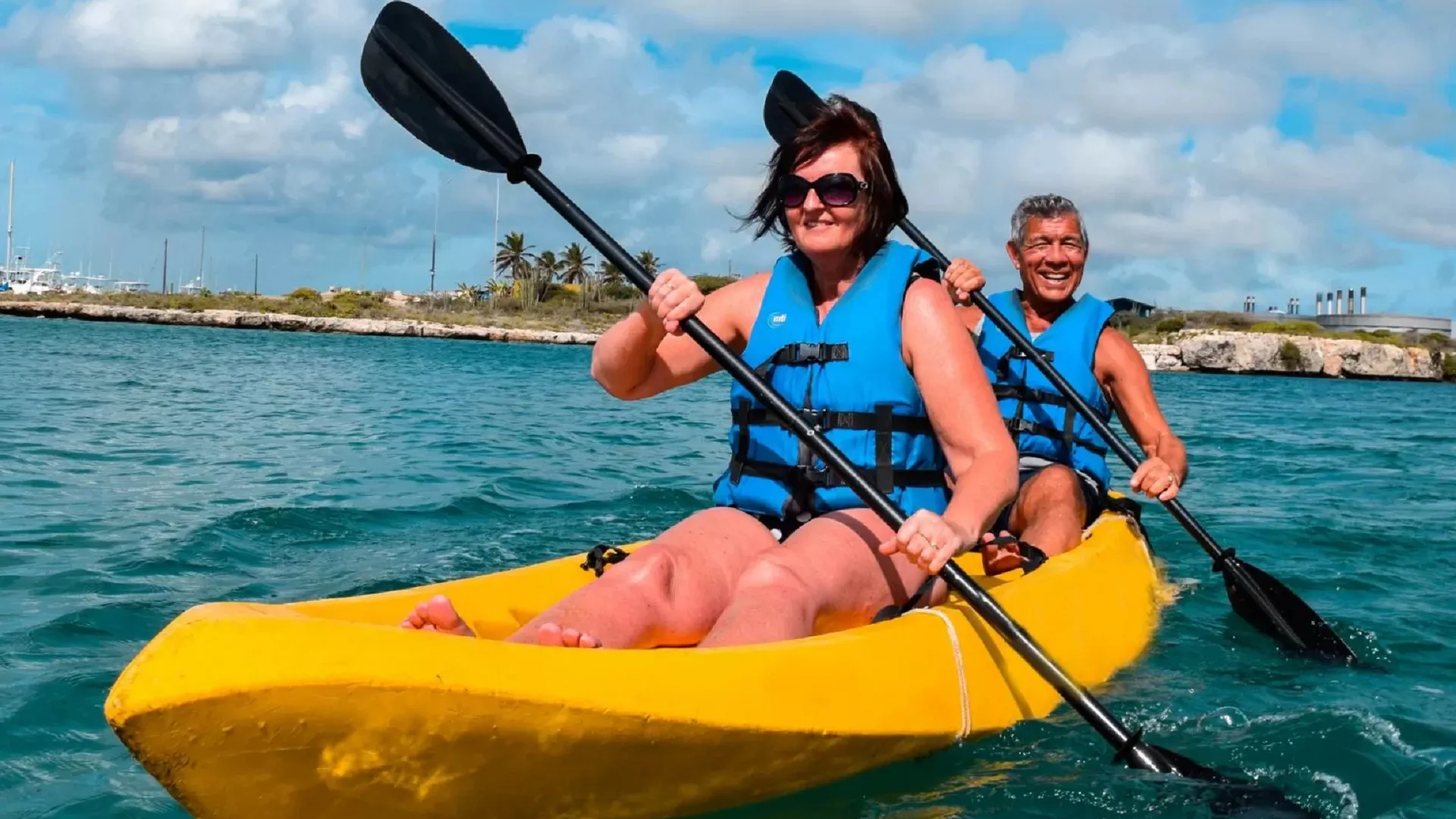 Two guests kayaking in a yellow tandem kayak