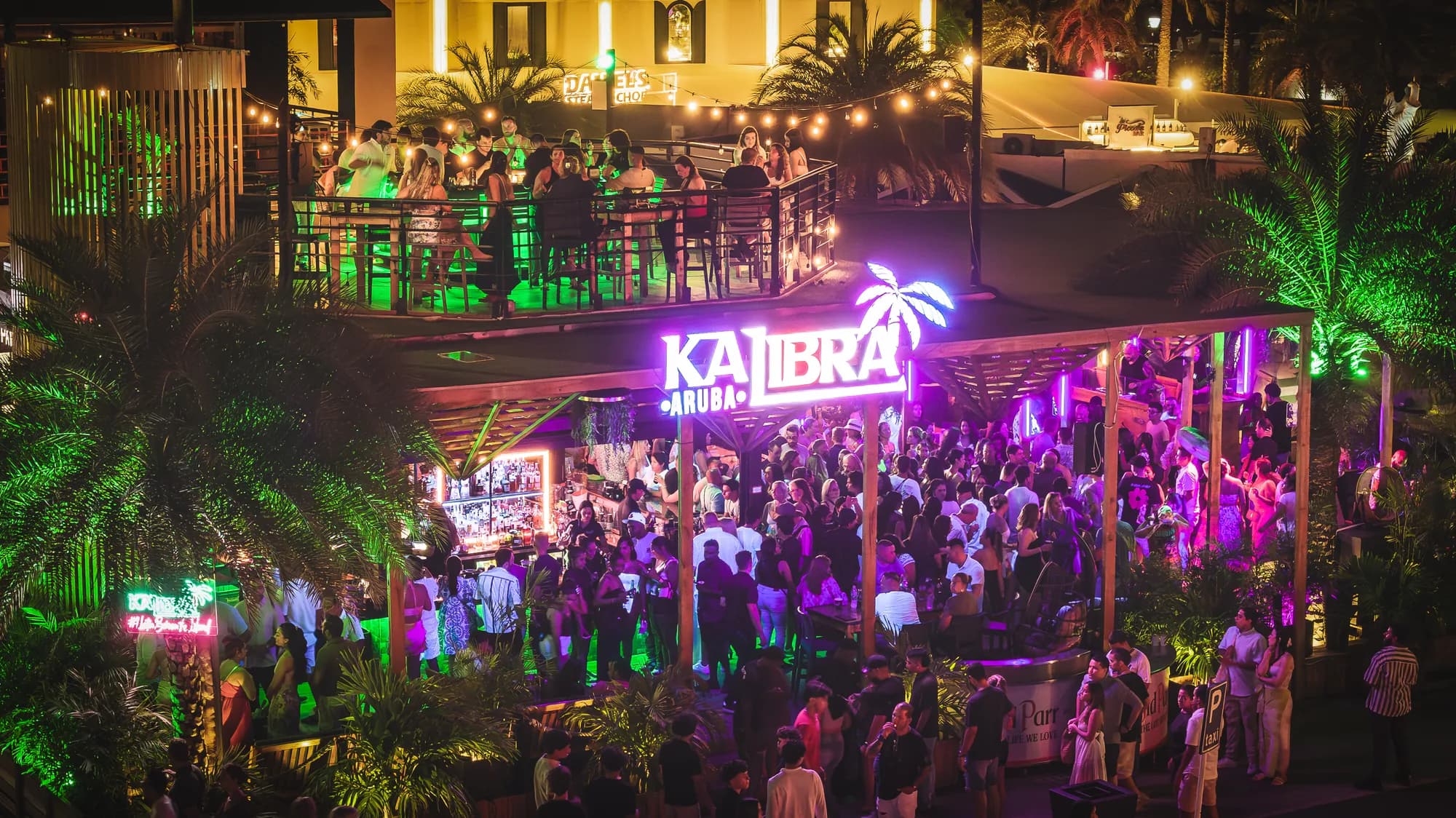 Venue at night with neon sign and crowd
