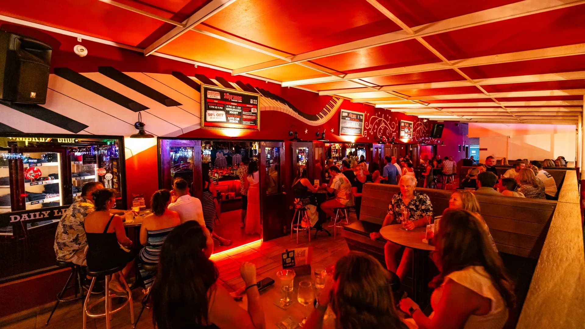 Packed bar interior with guests around the piano area