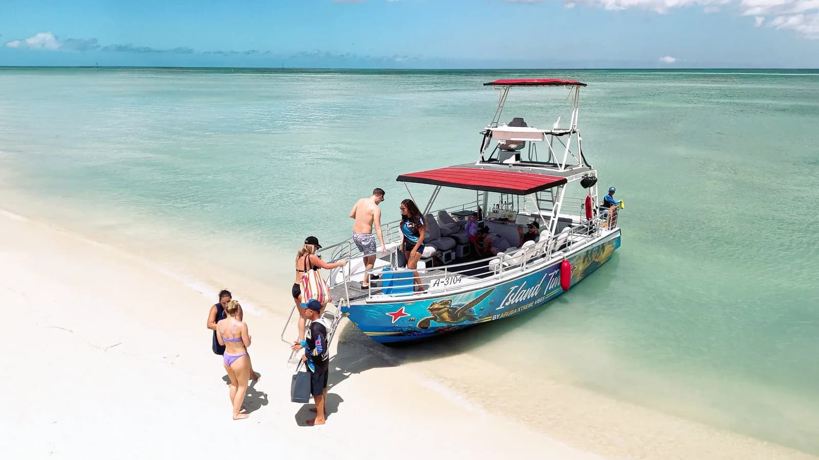 Boat pulled up to white-sand beach with guests