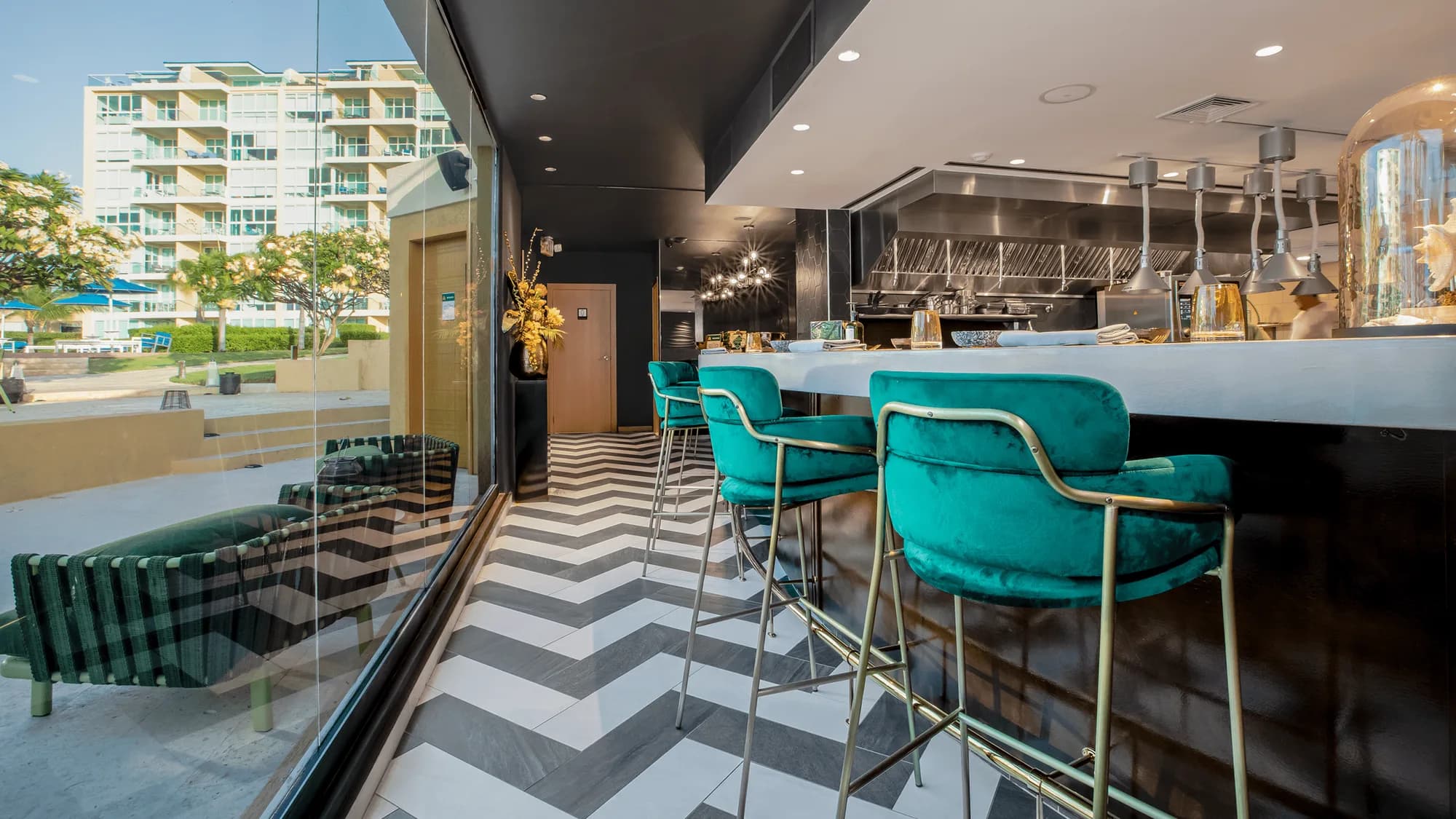 Interior with bar seating and chevron floor, view toward the beach area