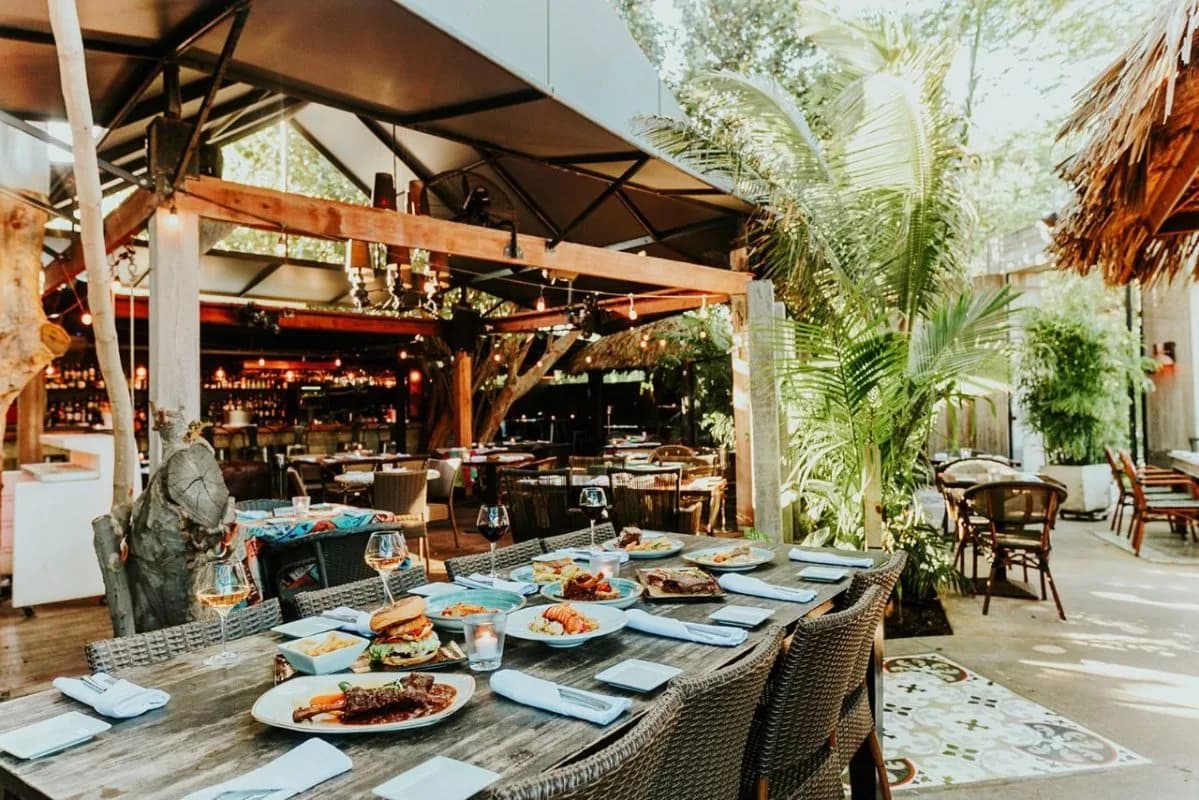 Garden dining area with set tables under trees