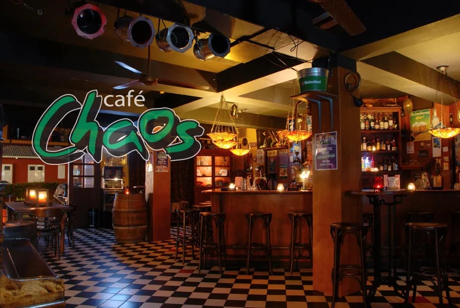 Bar interior with checkered floor and neon Cafe Chaos sign