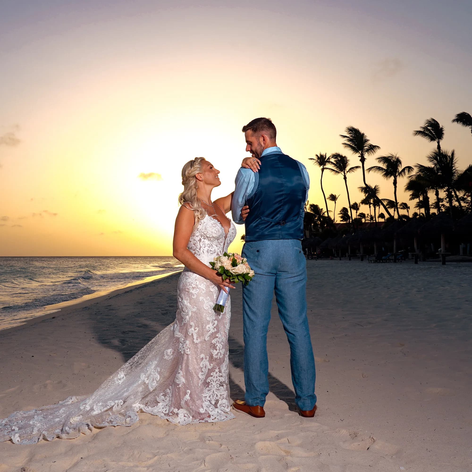 Couple on the beach at sunset with palm trees