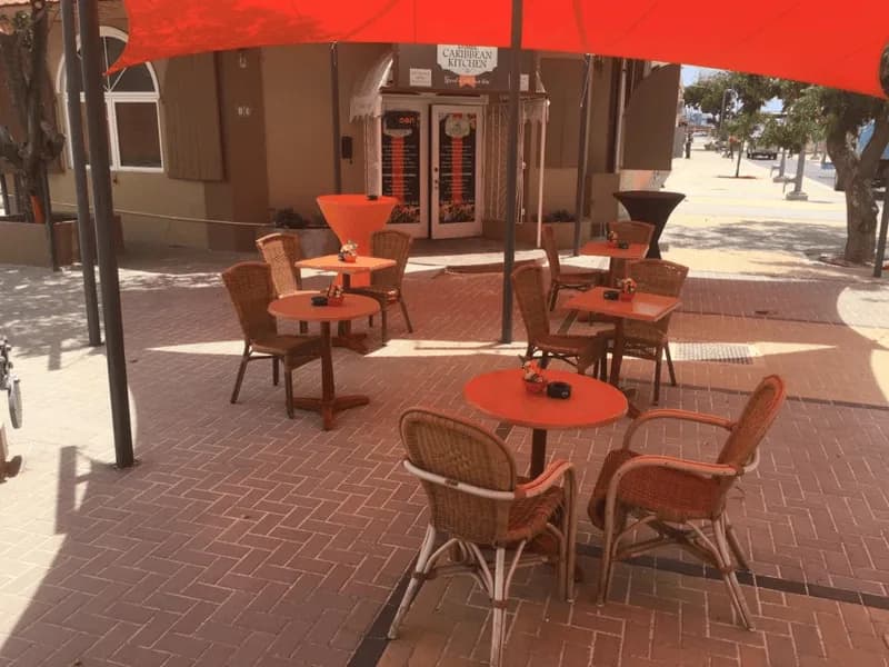Outdoor terrace tables under red umbrellas