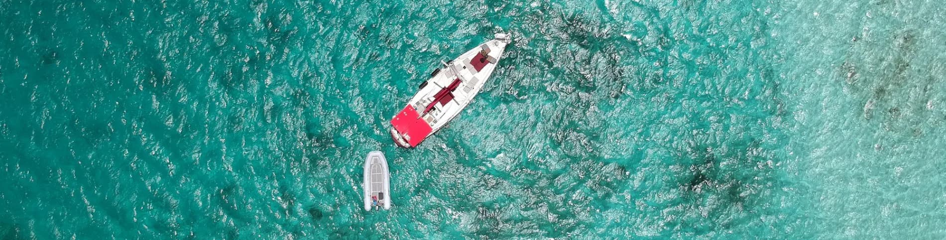 Aerial of turquoise water with small boat