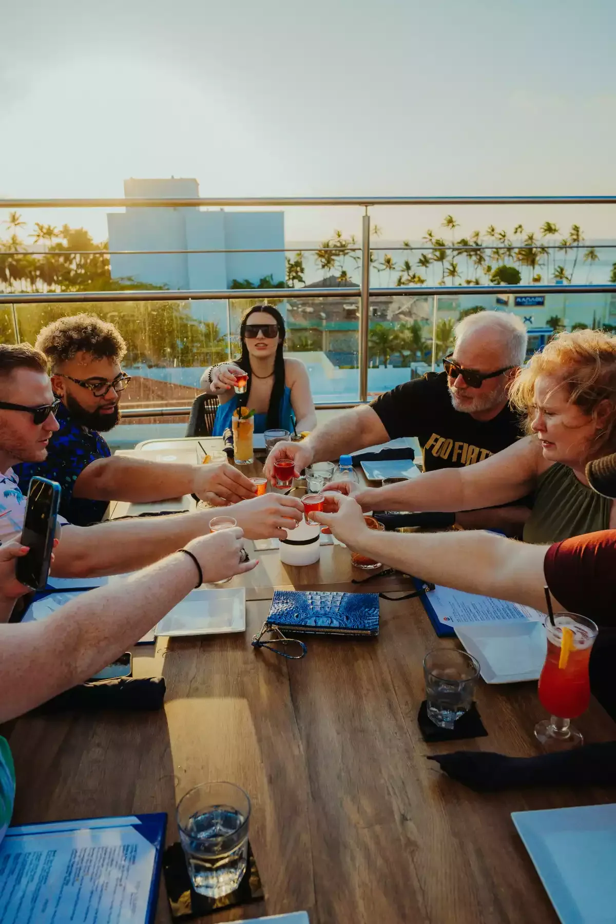 Guests toasting at a rooftop table at sunset
